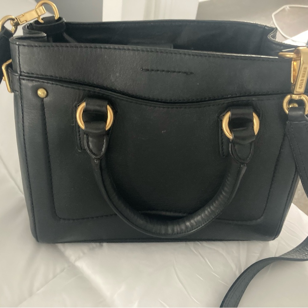 Cole Haan Black leather bag with gold accents.